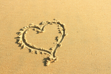 A heart is painted on the sand on the beach - a symbol of love for Valentine's Day. Concept - a trip to the sea and beach holidays as a gift for Valentine's Day.