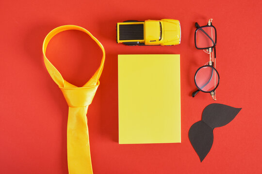 tie, trendy funny glasses, toy car, pen, mocap notebook and mustache, father's day concept