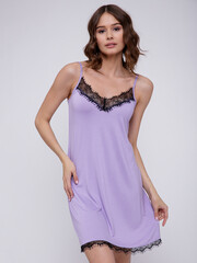 High fashion photo of a beautiful elegant young woman in a pretty soft purple nightgown posing over...