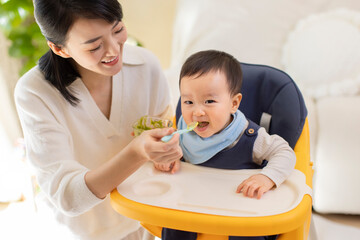Young mother feeding baby at home