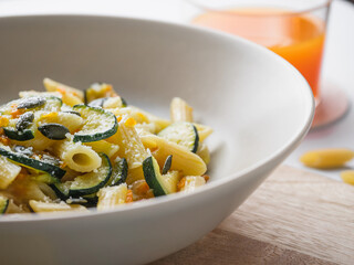 Dish of penne pasta with zucchini, seeds and parmisan. close up. Carbo portion ready for eat. Italian food, healthy vegetarian food. vegetable recipe for diet