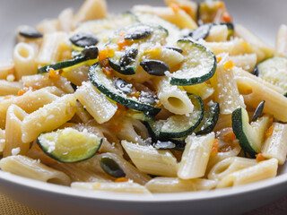 close up of penne pasta with zucchini, seeds and parmisan.  Carbo portion ready for eat. Italian...