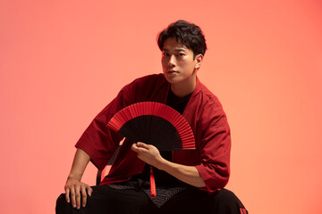 Confident young man holding a fan