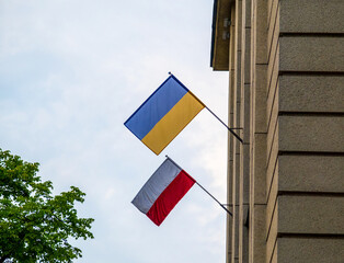 The flag of Poland and Ukraine together on the facade of building. Its a symbol of opposition to Russian aggression, a sign of solidarity and help Ukraine. Copy space © Olivia