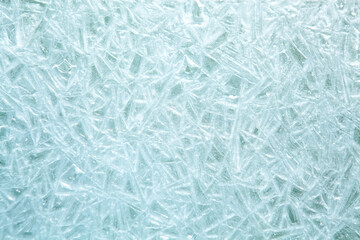 The texture of the ice surface. Winter background, festive background in the form of ice crystals, ice background for New Year's card, in a blue tone.