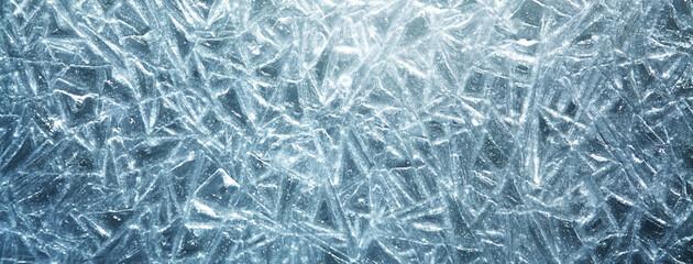 The texture of the ice surface. Winter background, festive background in the form of ice crystals, ice background for New Year's card, in a blue tone.