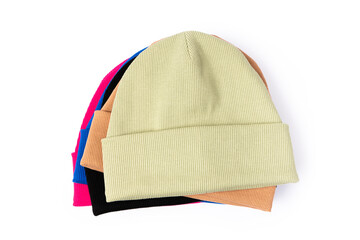 Top view of stack of insulated stylish beanie hats in different colors isolated on white background.