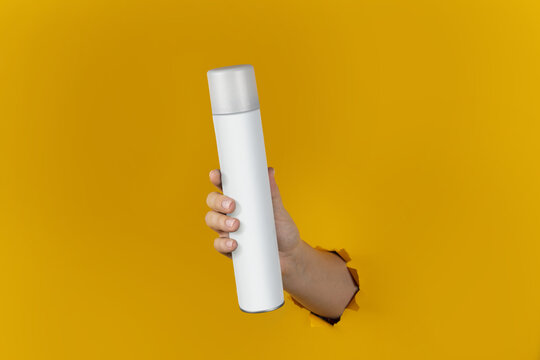 Cosmetic or Perfume Advertisement. Ready to use Item for Branding. Photo for design. Clean Bottle Spray Flacon in the Hand. Yellow Chroma Isolated Background