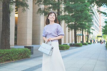 オフィス街を歩くキャリアウーマンの全身ポートレート