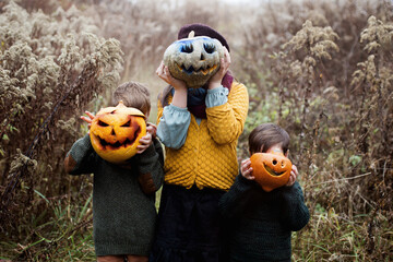 Halloween, dzieci zrobiły lampiony z dyni i wrzuciły do nich kolorowe dymiące się race - obrazy, fototapety, plakaty