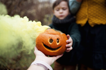 Halloween, dzieci zrobiły lampiony z dyni i wrzuciły do nich kolorowe dymiące się race