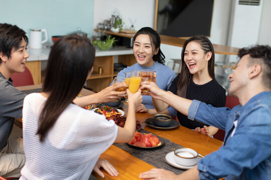 Young friends dining together at home