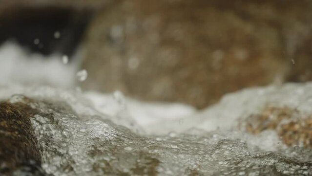 Super slowmo macro detail shot of water splashing through river with droplets 120fps (4k 30p Slow Motion)