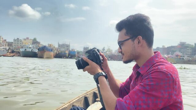 Travel photographer taking photo middle of Buriganga river on a boat in Bangladesh