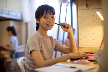 Young university student learning in dormitory