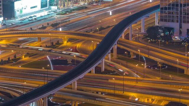 Highway intersection and overpass of Dubai downtown aerial night timelapse. Huge road junction with busy traffic from above.