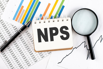 NPS text on notebook on the graph background with pen and magnifier