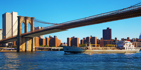 Fototapeta na wymiar Cargo ship and Brooklyn bridge in NYC