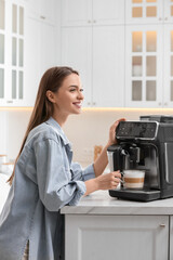 Young woman preparing fresh aromatic coffee with modern machine in kitchen