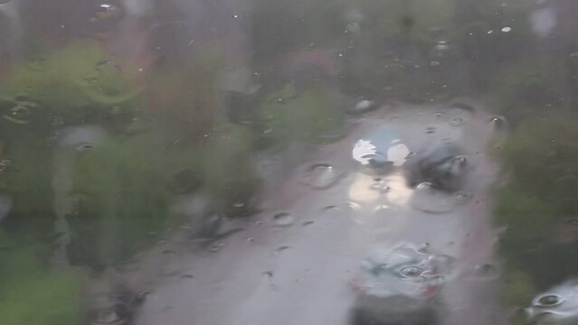 Regen prasselt auf ein Dachfenster