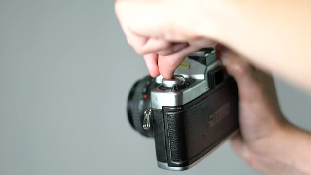 Close-up of young caucasian hand winding film in vintage analog camera