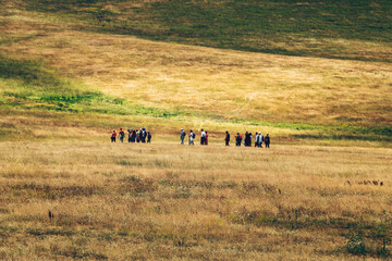 Group of people hiking through Zlatibor hills landscape on overcast summer day. Walking in nature is popular outdoor activity in this Serbian tourist travel resort.