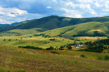 Beautiful picturesque Zlatibor region landscape with distinctive architectural style houses scattered over green hills