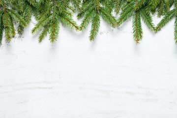 Natural fir tree branches in top of white textured background with space for text.  New Year and Christmas concept. Top view, copy space