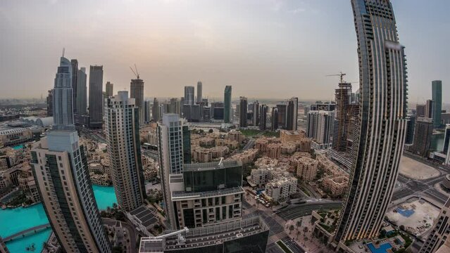 Aerial panorama of a big futuristic city night to day transition timelapse. Business bay and Downtown district before sunrise with skyscrapers and traditional houses, Dubai, United Arab Emirates