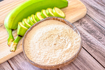 Banana flour in a coconut bowl on a wooden background with fresh bananas. Vivid photo © Anastasiia