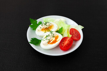 Hard boiled eggs, lettuce and tomatoes on a plate