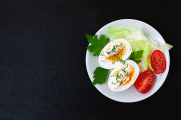 Hard boiled eggs with mayonnaise, lettuce and tomatoes on a plate
