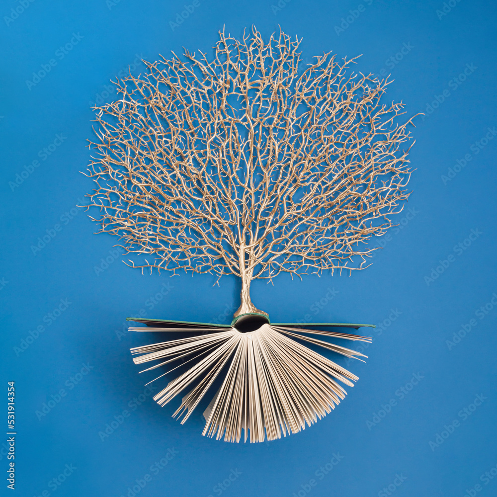 Wall mural golden tree growing from the old book, education and knowledge concept. for book lovers. flat lay.