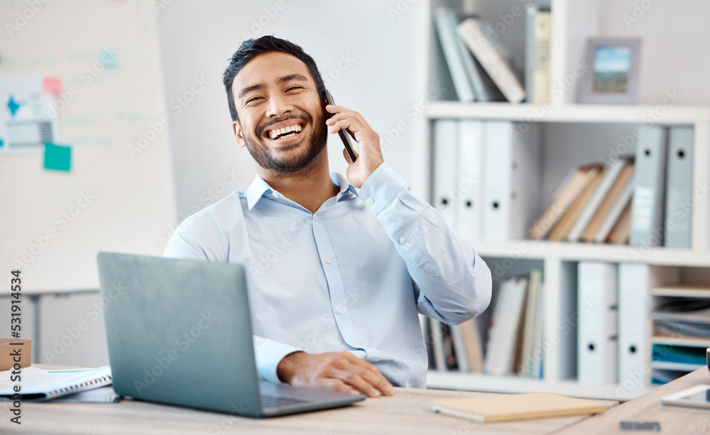 Leinwandbilder happy businessman on a phone call while working on a laptop at the desk in his modern office. corpor
