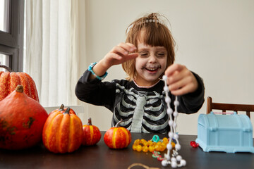 Happy laughing and smiling child boy dressing up with decorations before halloween holiday white...