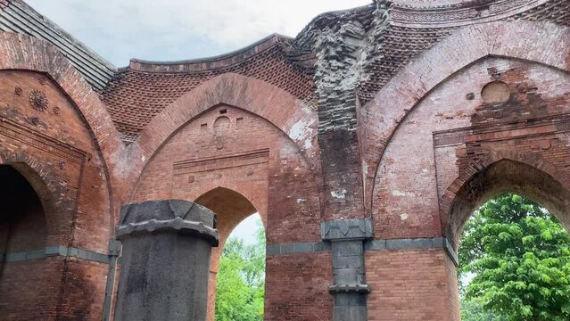The crumbling remains of a broken hall with stone arches at the historic Baro Shona Masjid or Baroduari Masjid in the West Bengali village of Gour.