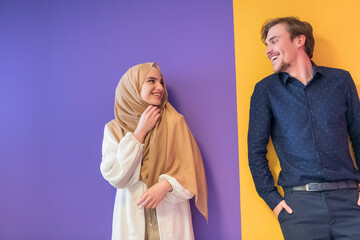 Portrait of a young Muslim couple woman in fashionable dress with hijab isolated on a colorful background representing modern Islam fashion and Ramadan Kareem concept