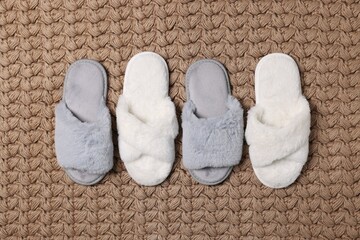 Fototapeta na wymiar Soft grey and white slippers on carpet, flat lay