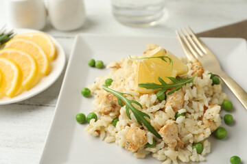 Delicious chicken risotto with lemon on table, closeup