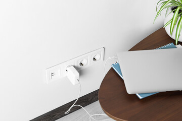 Electric power outlet sockets with charger on white wall