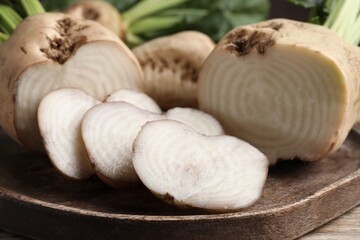 Cut sugar beets on wooden board, closeup