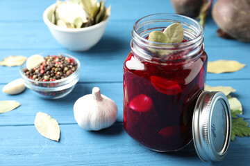 Pickled beets in glass jar on light blue wooden table