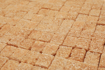 Brown sugar cubes as background, closeup view