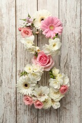Number 8 made of beautiful flowers on white wooden table, flat lay. International Women's day