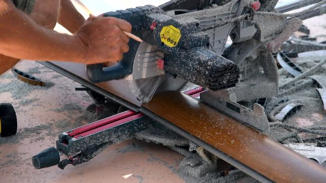 Miter saw. Cutting of PVC profile for siding. Sawdust. Selective focus