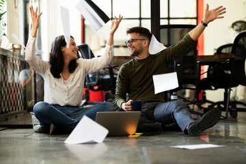 Colleagues in office. Businesswoman and businessman sitting on the floor. Colleagues working on the project..