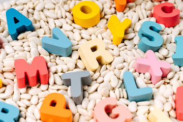 Colorful letters of the alphabet in sensory bin. Primary school or preschool, kindergarten. Educational game. Learning through play. Sensory play for toddlers.. - obrazy, fototapety, plakaty