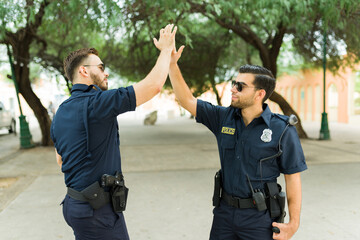 Cops making a high five after arresting a criminal