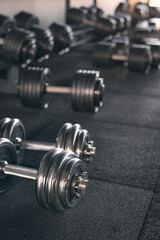 Obraz premium Gym equipment. Rows of different weights and dumbbells on the floor. Crossfit and sports