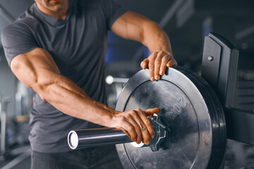 Sports background. Closeup photo of handsome bodybuilder guy prepare to do exercises with barbell...